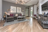 Located at 903 Huff Rd NW in Atlanta's vibrant West Midtown neighborhood, this single-floor residence combines modern design with thoughtful functionality. The open-concept kitchen is a standout feature, showcasing sage-gray cabinetry with crown molding detail, granite countertops, stainless steel appliances, and a peninsula island with seating for two. Pendant lighting and track fixtures illuminate the space, highlighting the clean, contemporary aesthetic.

The living room exudes warmth and sophistication, featuring rich hardwood flooring, crown molding, and a striking arched wall niche that frames a wall-mounted TV. Large windows invite generous natural light and offer views of the surrounding greenery, while a statement sputnik chandelier adds a bold modern accent. The overall palette blends deep gray tones with warm neutrals, creating an inviting and curated ambiance.

The bathroom is well-appointed with granite countertops, a wide dark-framed mirror, a full soaking tub with tile surround, and upscale finishes that maintain the cohesive design language found throughout the residence. A dedicated laundry room with in-unit washer provides added everyday convenience. Hardwood flooring flows consistently throughout the main living areas, tying the entire space together seamlessly.