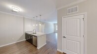 Located at 12115 Dessau Rd in Austin, TX, this single-story, 4-bedroom, 2-bathroom home offers a well-designed layout with modern finishes throughout. The open-concept living, dining, and kitchen area serves as the heart of the home, where wood-style flooring and crown molding create a polished, cohesive aesthetic. The dining area features an elegant multi-light chandelier, while a glass door and adjacent window invite natural light into the living space.

The kitchen is a standout, boasting granite countertops, dark espresso cabinetry, a subway tile backsplash, stainless steel appliances including a refrigerator, microwave, and range, and a peninsula with a built-in sink and pendant lighting overhead — ideal for both cooking and casual dining.

The four bedrooms offer comfortable retreats, with the primary bedroom featuring plush carpeting and a ceiling fan. Additional bedrooms include wood-style flooring and ceiling fans, with windows providing natural light. The two bathrooms are finished with tile flooring, dark vanity cabinetry with granite counters, and a tub-shower combination with subway tile surround. A hallway and closet complete the efficient, functional floor plan.