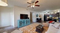 This thoughtfully designed single-floor residence offers three bedrooms, two bathrooms, and a functional layout that maximizes everyday comfort. The open-concept living and dining area serves as the heart of the home, featuring plush carpeting, a ceiling fan with light fixture, and a large window that invites natural light and outdoor views. The space flows seamlessly into a dedicated dining area and kitchen.

The kitchen is outfitted with rich dark wood cabinetry, granite-style countertops, black appliances including a range and built-in microwave, and hardwood-style flooring — offering both style and practicality.

The spacious primary bedroom features ceiling fan lighting, soft carpet, and a connected closet, providing a comfortable private retreat. The two additional bedrooms are well-proportioned, each with ceiling fans and natural light from windows. Both bathrooms include tub-shower combinations with sliding glass doors, dark wood vanity cabinetry, and hardwood-style flooring.

A dedicated laundry area houses a full-size washer and dryer with built-in shelving above for additional storage. Two closets further enhance the storage capacity throughout the home. Consistent design elements — including neutral wall tones, ceiling fans in every room, and a cohesive color palette — create a unified and comfortable living environment throughout.