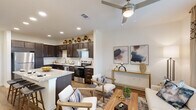 Located at 201 Wildwood Blvd in Forney, TX, this thoughtfully designed one-bedroom, one-bathroom residence offers a well-utilized single-floor layout. The open-concept living and kitchen area serves as the heart of the home, where rich dark-espresso cabinetry, granite countertops, a breakfast bar island with seating, and a full suite of stainless steel appliances — including a refrigerator, range, and dishwasher — create a functional yet stylish kitchen. Wood-look flooring flows throughout the main living areas, anchoring the bright, airy living room that benefits from large windows dressed with layered curtains, allowing generous natural light and outdoor views. A ceiling fan adds comfort overhead. The bedroom features plush carpeting, a large window with exterior views, and a distinctive sliding barn door that leads to the closet, adding a modern-rustic design touch. The bathroom includes a tub-shower combination, dark vanity cabinetry with ample storage, and wood-look tile flooring. A dedicated laundry area adds everyday convenience. Throughout the space, recessed lighting and crisp white walls contribute to a clean, contemporary ambiance that feels open and inviting.