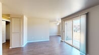 This two-bedroom, one-bathroom single-floor home in Salem, Oregon offers a practical and comfortable layout across a compact, efficiently utilized floor plan. The living room is a welcoming open space featuring warm hardwood-style flooring, neutral taupe walls, a ceiling fan, and a sliding glass door that fills the room with natural light while providing outdoor access. Adjacent to the living area, the galley-style kitchen is well-appointed with light wood cabinetry, laminate countertops, a full suite of appliances including a range, refrigerator, and dishwasher, and durable hardwood-style flooring that carries throughout the main living areas. A separate dining room offers additional flexibility for everyday living. The hallway connects the living spaces to the two bedrooms, each featuring plush carpet, neutral walls, and closets with wire shelving — one of which is a spacious walk-in. The bathroom is cleanly finished with tile flooring, a tub-shower combination, a single-sink vanity with storage cabinetry, and a large mirror. A second bedroom features a large window that invites generous natural light and outdoor views. Throughout, the home maintains a clean, neutral aesthetic with consistent finishes and functional design.