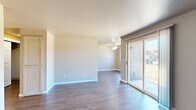 This two-bedroom, one-bathroom single-floor home in Salem, Oregon offers a practical and comfortable layout across a compact, efficiently utilized floor plan. The living room is a welcoming open space featuring warm hardwood-style flooring, neutral taupe walls, a ceiling fan, and a sliding glass door that fills the room with natural light while providing outdoor access. Adjacent to the living area, the galley-style kitchen is well-appointed with light wood cabinetry, laminate countertops, a full suite of appliances including a range, refrigerator, and dishwasher, and durable hardwood-style flooring that carries throughout the main living areas. A separate dining room offers additional flexibility for everyday living. The hallway connects the living spaces to the two bedrooms, each featuring plush carpet, neutral walls, and closets with wire shelving — one of which is a spacious walk-in. The bathroom is cleanly finished with tile flooring, a tub-shower combination, a single-sink vanity with storage cabinetry, and a large mirror. A second bedroom features a large window that invites generous natural light and outdoor views. Throughout, the home maintains a clean, neutral aesthetic with consistent finishes and functional design.