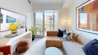 Located at 80 Bathurst Street in Toronto's vibrant King West neighbourhood, this thoughtfully designed one-bedroom, one-bathroom unit offers a compelling blend of modern aesthetics and functional living. The open-concept kitchen and living area forms the heart of the space, where light wood cabinetry, a grey tile backsplash, and stainless steel appliances — including a dishwasher and built-in microwave — establish a clean, contemporary kitchen. A white quartz waterfall island with bar seating serves as both a prep station and casual dining hub, while pendant lighting above adds a refined touch. Wide-plank hardwood flooring runs throughout, lending warmth and continuity. A stacked in-unit washer and dryer adds everyday convenience. The living area opens directly onto a private balcony through floor-to-ceiling sliding glass doors, flooding the space with natural light and framing views of the Toronto skyline. The bedroom is a serene retreat, featuring large windows with city views, a dedicated closet, and clean white walls. The bathroom showcases a floating wood vanity with a white quartz countertop, undermount sink, and stylish patterned wallcovering, completing this well-appointed urban residence.