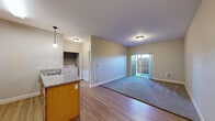 Located at 1605 Oak St SE in Albany, Oregon, this single-floor, one-bedroom, one-bathroom unit offers a practical and comfortable layout. The open-concept kitchen and living area serves as the heart of the home, featuring warm wood-toned cabinetry, granite-style countertops, stainless steel appliances including a refrigerator, range, and microwave, and a peninsula island with a double sink. Wood-look flooring flows through the kitchen and transitions to plush carpet in the living area, which includes access to a private outdoor patio through a sliding glass door. A dedicated laundry area with a full washer and dryer is conveniently tucked within the unit. The bedroom is a comfortable retreat with soft carpeting, a ceiling fan, a window with natural light, and access to a closet. The bathroom is clean and functional, featuring a full soaking tub and shower combination with tile flooring and a granite-topped vanity. Additional closet storage is available throughout the unit. Neutral wall tones and consistent finishes lend the space a cohesive, move-in-ready feel.