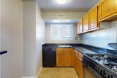 Located at 2206 Pimmit Run Ln in Falls Church, VA, this two-bedroom, one-bathroom unit offers a well-organized single-floor layout with a thoughtful mix of living and functional spaces. The entrance opens into a spacious carpeted living room bathed in natural light from large sliding glass doors that lead out to a private balcony with outdoor views, creating a bright and airy atmosphere. Adjacent to the living room, the dining area features elegant chair-rail wainscoting and a chandelier overhead, adding a refined touch to the space. The kitchen is efficiently designed with warm wood cabinetry, dark countertops, tile flooring, and black appliances including a gas range, dishwasher, and refrigerator. A pass-through window connects the kitchen to the dining area, enhancing the open feel. Both bedrooms are generously sized and carpeted, offering a comfortable and quiet retreat, with the primary bedroom providing ample space for large furniture. The unit includes four closets, offering exceptional storage throughout. The bathroom is well-appointed with full-surround tile work, a soaking tub, and a pedestal sink, giving it a clean and classic look. A hallway connects the private areas of the home for a functional flow throughout.