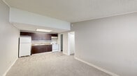 Located at 15750 NW 7th Ave in Miami, FL, this single-floor, one-bedroom, one-bathroom unit offers a practical and well-organized layout across its efficiently utilized floor space. The living room serves as the heart of the home, featuring neutral gray walls, plush carpeting, and a large window that invites natural light and provides views of the surrounding greenery. Crown molding and clean white baseboards add a polished finish throughout.

The bedroom is a comfortable retreat with soft carpeting underfoot, a ceiling fan with light fixture for year-round comfort, a window offering natural light, and a full-width closet with bi-fold doors providing ample storage. Crown molding continues in this room, maintaining a consistent architectural detail throughout the unit.

The bathroom is clean and functional, featuring wood-toned cabinetry with a white countertop vanity, a toilet, and a full tub and shower combination. Light wood-look flooring ties the space together with a modern touch.

A hallway connects the main living areas, and a utility room adds practical storage or laundry capability. The unit's neutral color palette, textured ceilings, and consistent finishes create a cohesive and move-in-ready atmosphere throughout.