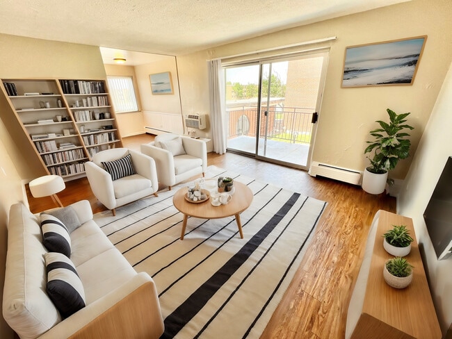 Bright and inviting living room featuring sleek furnishings, elegant bookshelf, and a spacious balcony view, perfect for modern apartment living. - Bonneville Apts