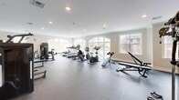 Located at 633 Springfield Ave in Berkeley Heights, NJ, this fitness center offers a generously sized, single-floor space designed to accommodate a comprehensive range of workout activities. The facility is thoughtfully laid out to maximize usable floor area while maintaining an open, uncluttered feel throughout.

The interior features neutral-toned walls, crown molding, and recessed lighting that collectively create a clean, polished atmosphere. Dark rubber flooring spans the entire space, providing durability and safety underfoot. Large arched windows along multiple walls invite substantial natural light, contributing to an energizing and welcoming environment with views of the surrounding exterior.

The cardio zone is well-stocked with treadmills, ellipticals, stationary bikes, and a rowing machine, all arranged to face the windows. The strength training area includes multiple cable and resistance machines, a multi-station cable system, a dumbbell rack with a full set of free weights, and adjustable benches. Floor-to-ceiling mirrors along one wall visually expand the space and assist exercisers with form. A wall-mounted television provides entertainment options. An open stretch area offers additional flexibility for floor exercises or functional training, completing this fully equipped, amenity-rich fitness facility.