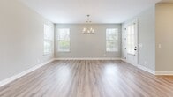 Located at 1104 Spring Path Ln in Nashville, TN, this two-story home offers four bedrooms and four full bathrooms thoughtfully distributed across two floors. The main level features an open-concept kitchen and living room bathed in natural light from multiple windows, with a elegant chandelier anchoring the living area. The kitchen is well-appointed with gray shaker-style cabinetry, white quartz countertops, stainless steel appliances, and wood-look luxury vinyl plank flooring that flows throughout the home. The attached garage provides direct interior access and includes an automatic opener. Upstairs, the spacious primary bedroom impresses with vaulted ceilings and a ceiling fan, while its en-suite bathroom features a dual-sink vanity with gray cabinetry and white quartz countertops. The additional bedrooms are comfortably sized, each with ceiling fans, natural light from windows, and the same consistent luxury vinyl plank flooring. Secondary bathrooms include a full tub-shower combination, single vanity, and clean white finishes. The home's neutral gray-toned walls, white trim, and cohesive modern finishes throughout create a bright, clean aesthetic that is both functional and welcoming.