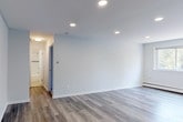 Located at 6451–6461 Oxford Avenue in Philadelphia's Fox Chase neighborhood, this single-floor unit combines contemporary updates with a clean, functional layout. The living areas feature light gray luxury vinyl plank flooring that runs throughout, complemented by recessed lighting that creates a bright, modern atmosphere. Large windows in the main living space allow natural light to filter in while providing views of surrounding greenery, and a wall-mounted air conditioning unit and baseboard heating ensure year-round comfort.

The kitchen stands out with rich, dark espresso cabinetry offering ample upper and lower storage, marble-look countertops, a stainless steel sink, and a textured tile backsplash that adds visual interest. The overall design strikes a balance between practicality and style.

The bedroom is carpeted for warmth and comfort, featuring a generously sized double-door closet and baseboard heating. A window allows natural light into the room. The bathroom is finished with clean white subway tile surrounding the tub and shower area, accented by a decorative mosaic border in black, white, and metallic tones, lending a polished, updated feel. The neutral color palette carried throughout the unit creates a cohesive, move-in-ready environment.
