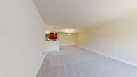 This 1,010-square-foot, single-floor apartment at Arbor Park of Alexandria features 3 bedrooms, 2 bathrooms, and a combined kitchen and living room connected by a carpeted hallway. The kitchen is equipped with rich, dark-wood cabinetry, light countertops, stainless steel appliances including a gas range and refrigerator, and light tile flooring. The open living room area is spacious with neutral carpet and warm beige walls, providing a clean and versatile space. Each bedroom is carpeted and finished with the same warm, neutral palette; the primary bedroom measures 190 square feet and features a ceiling fan with light fixture, while additional bedrooms also include ceiling fans and windows for natural light. A carpeted hallway with a closet connects the bedrooms to the shared living spaces. Both bathrooms feature light tile flooring, pedestal sinks, mirrored medicine cabinets, and overhead lighting. One bathroom includes a tiled shower stall. The hallway provides convenient closet storage. Throughout the unit, consistent neutral tones, white trim, and practical finishes create a cohesive, functional living environment.