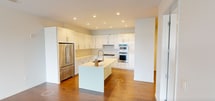 Located at 20100 Walker Road in Shaker Heights, Ohio, this contemporary single-floor residence offers 1,840 square feet of thoughtfully designed living space across 3 bedrooms and 3 bathrooms. The open-concept kitchen and living room serve as the heart of the home, featuring gleaming white cabinetry, stainless steel appliances including a double wall oven and French door refrigerator, a central island with an undermount sink, and warm hardwood flooring throughout. The living room is bathed in natural light through expansive floor-to-ceiling windows and sliding glass doors that open directly onto a spacious private terrace with sweeping urban views of the Shaker Heights skyline. The 230-square-foot primary bedroom continues the floor-to-ceiling window theme with direct terrace access and plush carpeting. A well-appointed walk-in closet features built-in shelving, drawers, and hanging systems for exceptional organization. The bathrooms are finished with light tile flooring, modern vanities, and textured accent walls. Additional bedrooms offer hardwood floors and built-in shelving units. A dedicated laundry room with overhead cabinetry and countertop workspace adds everyday convenience. Two hallways and two closets complete this polished, modern residence.