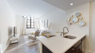 Located at 400 Walnut St in Philadelphia's sought-after Old City neighborhood, this single-floor residence offers a thoughtfully designed open-concept layout that seamlessly connects the kitchen, dining, and living areas. The kitchen is a standout feature, boasting dark cabinetry, stainless steel appliances including a refrigerator, range, and microwave, a classic white subway tile backsplash, and a white quartz peninsula with bar seating — an ideal space for both cooking and casual dining. Wood-style flooring flows throughout the main living area, complementing the bright, neutral palette. The living room is generously proportioned, featuring large black-framed windows that welcome abundant natural light and lend an urban, industrial-chic character to the space. The bedroom is a calm retreat, carpeted for comfort, with soft natural light filtering in and ample room for furnishings. It connects conveniently to a full bathroom, which includes a shower/tub combination and tile flooring. Throughout the residence, clean white walls and recessed lighting create a crisp, modern ambiance. Situated steps from Philadelphia's historic landmarks, dining, and cultural institutions, this residence combines contemporary finishes with an unbeatable location in the heart of the city.