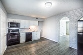This two-story home in Memphis, Tennessee offers a practical and comfortable layout across two well-defined levels. The main floor features light-toned vinyl plank flooring throughout, complemented by soft gray walls and white trim that create a clean, neutral aesthetic. The living area is bright and open, with natural light filtering in through blinded windows. The kitchen is equipped with white cabinetry, marble-style countertops, a double basin sink, and black appliances including a range, microwave, and dishwasher. A half bath and staircase with a carpeted runner connect the main level to the upper floor. Upstairs, both bedrooms are finished with plush gray carpet and ceiling fans, providing a cozy and comfortable retreat. Each bedroom includes windows with blinds that allow for natural light. The full bathroom on the upper level features wood-look vinyl flooring, a tub-shower combination with tiled surround, a marble-top vanity, and a window for ventilation. Textured ceilings are present throughout the home. The overall design is consistent and move-in ready, offering a functional living environment in a convenient Memphis location.