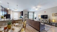 Located at 111 Holling Dr in Frederick, Maryland, this well-appointed 2-bedroom, 3-bathroom residence offers a thoughtfully designed single-level layout. The open-concept living and kitchen area serves as the heart of the home, bathed in natural light from multiple windows dressed with classic plantation shutters. Crown molding adds a refined architectural touch throughout the main living spaces, which feature warm hardwood-style flooring.

The kitchen is a standout, showcasing rich dark-espresso cabinetry, granite countertops, a classic subway tile backsplash, and stainless steel appliances. A peninsula with pendant lighting provides additional counter space and casual seating, seamlessly connecting the kitchen to the living area.

Both bedrooms are generously proportioned, with plush carpeting and large windows that invite natural light. The primary bedroom includes a ceiling fan and direct access to an en-suite bathroom. The bathrooms are finished with tile flooring, dark wood vanities, and brushed nickel fixtures, with one featuring a full tub-shower combination.

A connecting hallway ties the rooms together with practicality and flow. The neutral warm-gray palette throughout creates a cohesive, calm ambiance, making this a comfortable and move-in-ready residence in Frederick, MD.