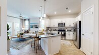 This thoughtfully designed one-bedroom, one-bathroom residence offers an efficient and functional layout across a single floor. The open-concept living and kitchen area serves as the heart of the home, where light wood-style flooring, recessed lighting, and high ceilings create a bright and airy atmosphere. The kitchen is equipped with stainless steel appliances, crisp white cabinetry, granite countertops, and a central island with seating — ideal for both meal preparation and casual dining. Pendant lighting above the island adds a stylish accent. The living room receives ample natural light through large windows and a glass door that opens to an outdoor area, further enhancing the sense of openness. The bedroom features a shiplap accent wall, a ceiling fan, and generous proportions, providing a comfortable retreat. A dedicated walk-in closet with built-in shelving and hanging rods offers practical storage. The bathroom includes a granite-topped vanity, wood-style flooring, and a shower-tub combination. A separate in-unit laundry room with a full-size washer and dryer adds everyday convenience. The cohesive, neutral color palette and coastal-inspired design elements give the space a clean, welcoming character throughout.