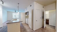 This one-bedroom, one-bathroom unit at 1405 Southwood Plantation Rd offers a thoughtfully designed layout across a single floor. The open-concept kitchen serves as a central hub, featuring dark espresso cabinetry, granite-style countertops, wood-look flooring, and a center island with pendant lighting overhead. Black appliances, including a refrigerator, range, and built-in microwave, complete the kitchen's cohesive look. Track lighting adds additional illumination to the space.

The living area flows seamlessly from the kitchen and features neutral carpet, a ceiling fan, and a window that allows natural light to brighten the room. The bedroom is carpeted, comfortably sized, and includes a ceiling fan, window with exterior views, and direct access to the hallway.

The bathroom is well-appointed with dark wood cabinetry, dual mirrors, granite-style countertops, wood-look tile flooring, and a soaking tub with white tile surround. A dedicated closet provides added storage. A standout feature is the in-unit laundry area, conveniently tucked behind cabinetry near the main living space, offering practical day-to-day functionality throughout the unit.