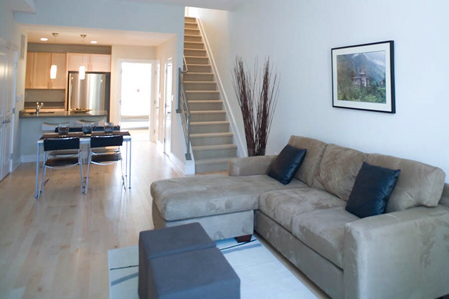 Bright and spacious living area with hardwood floors, open layout, and modern furnishings. - 1123 6th St NW