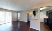 Located at 1001 Spring Lake Ct in Morrow, Georgia, this single-floor residence offers a well-organized layout designed for comfortable everyday living. Rich, dark hardwood flooring extends throughout the home, providing a warm and cohesive aesthetic in every room.

The open-concept living and dining area is generously proportioned, allowing natural light to filter in through sliding glass doors and windows dressed with vertical and horizontal blinds. A textured ceiling adds visual interest overhead, while neutral walls create a versatile backdrop. A pendant light fixture anchors the dining area, which flows seamlessly into the living space.

The kitchen is laid out in a galley configuration, equipped with dark cabinetry, light countertops, a stainless steel sink, and black appliances including a refrigerator and gas range. A pass-through window with a breakfast bar connects the kitchen to the dining area, enhancing the open feel of the shared living spaces. A louvered pantry door provides additional storage.

The bedrooms are well-sized, each featuring hardwood floors, textured ceilings, and windows that bring in natural light. Closet access is conveniently located within each room.

Two full bathrooms serve the home, each featuring a single-sink vanity with dark cabinetry, a large mirror, overhead lighting, and a tub-shower combination. The overall ambiance is clean, functional, and move-in ready.