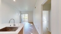 This 540 square foot, one-bedroom apartment in Santa Clara offers a blend of modern design and functionality. The open-concept living area seamlessly integrates the kitchen and living room, creating a spacious feel despite the compact footprint. Light wood flooring throughout adds warmth and continuity to the space.

The kitchen boasts contemporary wood cabinetry, stainless steel appliances, and a stylish hexagonal tile backsplash. A large kitchen island with a sink serves as both a workspace and casual dining area. The living room features large sliding glass doors leading to a private balcony, flooding the space with natural light and offering outdoor views.

The bedroom, measuring 180 square feet, includes a closet with built-in shelving for ample storage. The bathroom showcases a modern vanity with a expansive mirror and good lighting. Throughout the apartment, recessed lighting and strategically placed windows enhance the bright, airy ambiance.

This efficient single-floor layout maximizes every square foot, making it an ideal choice for those seeking a low-maintenance urban lifestyle in the heart of Santa Clara. The neutral color palette and clean lines create a canvas for personal style, while the thoughtful design ensures comfort and convenience in a compact space.