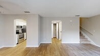 Located on Filmore Street in Orange Park, Florida, this two-story home offers a clean, modern interior designed for comfortable everyday living. Wood-look flooring runs throughout both levels, providing a warm and cohesive aesthetic that ties the spaces together seamlessly.

The main level features an open living area bathed in natural light, enhanced by a ceiling fan and access to the front entry with vertical blinds. The layout flows naturally into a well-appointed galley-style kitchen outfitted with white shaker cabinetry, gray countertops, stainless steel appliances including a refrigerator, electric range, and built-in microwave, as well as a stainless steel sink. A louvered pantry door adds functional storage within the kitchen area.

A staircase leads to the upper level, where additional living spaces continue the home's neutral, light-filled palette. Bedrooms on this floor feature ceiling fans, windows with exterior views, and easy access to a well-lit hallway. A bathroom with a vanity, mirror, and full fixtures is also present on the upper level.

Throughout the home, textured ceilings, crisp white trim, and neutral wall tones create a bright, move-in-ready environment. The thoughtful two-floor layout provides a practical separation between living and sleeping areas, making this Orange Park residence a functional and inviting place to call home.