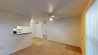 This 690 square foot one-bedroom, one-bathroom apartment offers a thoughtful layout designed for comfortable living. The main living area is an open-concept space, combining the living room and dining area, with a mix of carpeting and hardwood flooring. A ceiling fan with integrated lighting provides both illumination and air circulation.

The kitchen, while compact, is well-equipped with modern appliances including a refrigerator and stove. White cabinetry and granite countertops offer both storage and workspace. A breakfast bar separates the kitchen from the living area, creating a natural flow between spaces.

The bedroom features carpeting, a ceiling fan, and a window for natural light. An ample closet with built-in shelving provides storage space. The bathroom is efficiently designed with a combined tub and shower unit.

Throughout the apartment, neutral-toned walls create a blank canvas for personalization. The unit benefits from natural light through windows with blinds. Overall, this apartment offers a practical and comfortable living space with modern touches, ideal for singles or couples seeking an efficient urban dwelling.