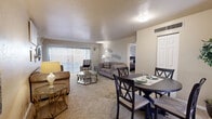 Located at 2544 S Kolb Rd in Tucson, AZ, this single-floor, 2-bedroom, 1-bathroom residence offers a practical and comfortable layout. The open living and dining area is carpeted throughout, bathed in natural light from large sliding glass doors fitted with vertical blinds. The living room features a warm, neutral color palette and provides a welcoming atmosphere. The adjacent dining area accommodates a full dining set and connects seamlessly to the kitchen, which is outfitted with warm wood cabinetry, granite-style countertops, tile flooring, and a sliding glass door that lets in additional natural light. A hallway connects the main living spaces to the private quarters. The spacious primary bedroom includes a mirrored sliding closet, soft carpet, and ample room for a full bedroom suite. The second bedroom is similarly carpeted with good proportions and wall space. The shared bathroom features tile flooring, a granite-topped vanity with wood cabinetry, and a tub/shower combination with decorative stone-pattern tile surround. Throughout the home, neutral tones and consistent finishes create a cohesive, move-in-ready feel suited for comfortable everyday living.