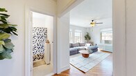 Located on North Clark Street in Chicago's sought-after Lincoln Park neighborhood, this well-appointed 1-bedroom residence offers a thoughtfully organized layout across a single floor. Warm hardwood flooring runs throughout, tying together each room with a cohesive, inviting feel.

The living room is a bright, airy retreat bathed in natural light from multiple windows that frame city views. A ceiling fan overhead and a large sectional sofa anchored by a round wooden coffee table create a comfortable gathering space. A mirrored sliding door adds depth and reflects additional light throughout the room.

Adjacent to the living room, the dining area is cozy and characterful, featuring a round marble-top table, eclectic seating, and a window overlooking the neighborhood. Decorative shelving displaying curated art pieces adds a personal, gallery-like touch.

The galley-style kitchen is efficiently designed with warm wood cabinetry, granite countertops, a gas range, and ample storage — ideal for everyday cooking.

The generously sized primary bedroom accommodates a full bedroom suite comfortably, and includes a ceiling fan, wall sconces, a window with natural light, and room for a seating area. A hallway connects all rooms, completing this well-structured and charming Chicago residence.