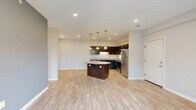 Located at 220 Marshall St in Monaca, PA, this single-floor residence offers three bedrooms and two bathrooms within a thoughtfully designed layout. The open-concept kitchen and living area serves as the heart of the home, featuring light wood-look luxury vinyl flooring, recessed lighting, and a striking octagonal granite-topped island beneath elegant pendant lights. Dark espresso cabinetry with granite countertops lines the kitchen walls, complemented by a full suite of stainless steel appliances. A set of French doors floods the living area with natural light and provides outdoor access, while a bold slate-blue accent wall adds a contemporary touch to the space. Both bathrooms are finished consistently with dark vanity cabinetry, granite countertops, large mirrors, and light wood-look flooring. Grab bars are thoughtfully incorporated, adding accessibility to the design. The three bedrooms are carpeted in a warm neutral tone and feature soft, neutral-painted walls. Two of the bedrooms include windows with views of the surrounding greenery and neighborhood, allowing natural light to brighten each room. Clean white panel doors and crisp white baseboards throughout tie the interior together with a cohesive, modern aesthetic.