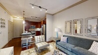 Located at 4310 Dunlavy St in Houston's vibrant Montrose neighborhood, this thoughtfully designed one-bedroom, two-bathroom residence offers an efficient yet refined layout across a single floor. The living room immediately impresses with soaring ceilings, crown molding, and floor-to-ceiling windows that bathe the space in natural light and provide views of the surrounding streetscape. Rich hardwood-style flooring and elegant drapery contribute to the room's polished ambiance.

The gourmet kitchen is a standout feature, showcasing rich cherry wood cabinetry, dark granite countertops, a stone tile backsplash, and a full suite of stainless steel appliances including a professional-grade gas range, built-in microwave, dishwasher, and French door refrigerator. Track lighting and under-cabinet illumination complete the functional and stylish design.

The bedroom is a comfortable retreat, featuring a ceiling fan, a large window with views to the exterior, and plush carpeting. It connects to a dedicated walk-in closet with wire shelving for organized storage. The primary bathroom offers a soaking tub set within marble-look tile surround, complemented by a vanity with rich wood cabinetry and granite countertops. A second full bathroom serves guests with equal refinement and easy hall access.