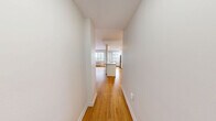 Located on the 10th floor at 565 Avenue Rd in Toronto's prestigious Forest Hill neighbourhood, this thoughtfully designed unit offers a comfortable and efficient single-floor layout. Warm honey-toned hardwood flooring flows seamlessly throughout the space, lending a cohesive and inviting character to every room.

The open-concept kitchen serves as the functional heart of the unit, anchored by a peninsula with a granite-topped breakfast bar and an integrated sink. Crisp white shaker-style cabinetry extends to the ceiling, providing generous storage, while a classic subway tile backsplash adds a clean, timeless detail. Stainless steel appliances — including a full-size refrigerator, electric range, and over-the-range microwave — complete the well-equipped kitchen. A large window floods the area with natural light and offers elevated views of the surrounding cityscape and lush tree canopy along Avenue Road.

The bedroom area is a bright, open room with neutral white walls and continued hardwood flooring, offering a calm and versatile space.

The bathroom features a white vanity with a granite countertop, a large mirror, and consistent hardwood flooring, maintaining the unit's clean and modern aesthetic throughout.

A private balcony provides sweeping views of Avenue Road and the Toronto skyline, framed by abundant greenery.