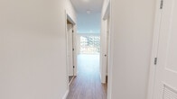 Located at 3710 S Angeline St in Seattle's vibrant 98118 corridor, this efficiently designed single-floor studio offers a clean, contemporary aesthetic throughout. Light wood-tone flooring runs continuously across the open layout, complemented by crisp white walls and recessed lighting that keep the space feeling bright and airy. A large sliding glass door anchors the main living area, flooding the room with natural light and offering views of the surrounding neighborhood. A wall-mounted mini-split system provides climate control.

The kitchen is thoughtfully appointed with white shaker-style cabinetry extending to the ceiling for ample storage, a classic white subway tile backsplash, and light quartz countertops. Stainless steel appliances — including a gas range, over-the-range microwave, dishwasher, and full-size refrigerator — complete the functional cooking space.

A hallway connects the main living area to the bathroom and closet. The bathroom features large-format gray floor tiles, a soaking tub and shower combo enclosed by sliding glass doors with white subway tile surround, and brushed nickel fixtures throughout. A dedicated closet provides convenient storage. The unit also includes a stacked washer and dryer. This well-finished space combines smart layout with modern finishes in a prime Seattle location.
