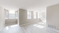 This 2-bedroom, 1-bathroom residence offers a thoughtfully laid-out single-floor plan designed for comfortable everyday living. The interior is defined by a cohesive, modern aesthetic, featuring light-toned hardwood-style flooring and warm neutral wall colors that carry consistently throughout the space.

The living room is the largest area of the home, benefiting from an abundance of natural light streaming through multiple windows. The open, airy feel is enhanced by crisp white ceilings and clean white baseboards that frame the room with a polished finish.

The kitchen is efficiently designed in a galley layout, equipped with warm wood cabinetry, marble-style countertops, a stainless steel sink, and a full suite of stainless steel appliances including a refrigerator, oven, and dishwasher — providing a functional and attractive cooking space.

The primary bedroom is a well-sized retreat that receives generous natural light and includes a built-in closet with bifold doors and a full hanging rod. The second bedroom is a comfortable, sunlit room with its own closet and sliding door storage. Both bedrooms continue the light flooring and neutral palette found throughout the home.

The bathroom features warm terracotta-toned tile flooring, a full soaking tub with a tiled shower surround, a toilet, and a vanity with white cabinetry. A connecting hallway ties all areas of the residence together in a clear, accessible layout.