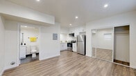 Located at 6401 Warner Ave in Huntington Beach, CA, this efficiently designed single-floor studio offers a clean, modern aesthetic with thoughtful use of every square foot. The open layout is anchored by warm wood-look flooring that flows seamlessly throughout, complemented by crisp white walls and recessed lighting that keep the space feeling bright and airy.

The kitchen is well-appointed with white shaker-style cabinetry extending to the ceiling for ample storage, stainless steel appliances including a refrigerator, gas range, over-the-range microwave, and dishwasher, along with light countertops and a double sink. A mirrored sliding closet door off the main living area adds depth and reflects additional light into the space. The living area also features a wall-mounted mini-split unit for individual climate control, along with windows fitted with roller shades.

The bathroom is finished with large-format dark tile flooring, a white vanity with a wide mirror, and a full tub-shower combination with clean white tile surround. An electrical panel is conveniently accessible within the unit. The overall design is modern, functional, and move-in ready, making this Huntington Beach studio an efficient and stylish living space.
