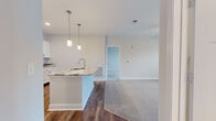 This single-story home in Spring Hill, Tennessee offers a thoughtfully designed layout with two bedrooms and two full bathrooms. The open-concept kitchen and living area serves as the heart of the home, where warm hardwood-style flooring flows throughout the main living spaces. The kitchen features granite countertops, white cabinetry, stainless steel appliances, a geometric tile backsplash, and pendant lighting above the island, creating a clean, modern aesthetic. Natural light enters through windows and a front-facing door, brightening the connected living area, which is also equipped with a ceiling fan.

Both bedrooms are carpeted for comfort, with the generously sized primary bedroom including a walk-in closet fitted with wire shelving. The second bedroom also benefits from natural light and outdoor views through a window with blinds. Each bathroom is finished with granite-topped vanities, white cabinetry, and a tub-shower combination with tile surround. A dedicated laundry room accommodates a full-size washer and dryer side by side, with overhead wire shelving for additional storage. The home's neutral color palette and consistent finishes contribute to a cohesive, move-in-ready atmosphere throughout.