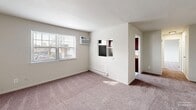 Located at 3550 Old Street Rd in Bensalem, PA, this two-bedroom, one-bathroom residence offers a practical and straightforward single-floor layout. The living area is generously proportioned, featuring wall-to-wall carpeting in neutral tones, crisp white walls, and a large window that invites natural light and provides views of the surrounding neighborhood. A baseboard heating unit and wall-mounted air conditioning unit ensure year-round comfort. A pass-through opening connects the living area to the kitchen, which features dark wood cabinetry and a countertop workspace, providing a convenient and connected layout.

The primary bedroom is notably spacious, offering abundant room for furnishings, and is outfitted with two large closets — including a double-door wardrobe — providing ample storage. Soft carpeting and neutral wall tones carry throughout both bedrooms, contributing to a calm and cohesive aesthetic. The second bedroom is similarly carpeted and well-lit, with a clean, open feel.

The bathroom is finished with all-white tile work, featuring a full tub and shower combination with chrome fixtures and a small window for natural ventilation. The overall design of the residence is clean, functional, and move-in ready, making it a practical option in the Bensalem community.