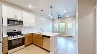 Located at 5164 Old Town Hall Rd in Eau Claire, WI, this thoughtfully designed one-bedroom, one-bathroom unit offers a modern and efficient living experience across a single floor. Light hardwood flooring flows throughout, creating a bright and cohesive aesthetic.

The open-concept kitchen and living area serves as the heart of the space. The kitchen is well-appointed with two-tone cabinetry — white upper cabinets paired with warm wood lower cabinets — complemented by white countertops and a full suite of stainless steel appliances, including a refrigerator, range, microwave, and dishwasher. A peninsula with a single-basin sink and pendant lighting adds both functionality and style. A ceiling fan and recessed lighting illuminate the adjoining living area, which connects to an entry door flanked by windows offering pleasant outdoor views of surrounding greenery.

The bedroom is a calm, neutral retreat featuring light hardwood floors, dual windows with natural light and serene outdoor views, and two closets for ample storage.

The bathroom is clean and functional, featuring a warm wood vanity with a white countertop, a mirrored medicine cabinet, and a full tub-shower combination with tile surround. Neutral tile flooring ties the space together.

Overall, this unit delivers a modern, move-in-ready environment with a clean design palette and practical layout.