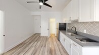 Located at 744 Beacon Avenue in Los Angeles, CA, this efficiently designed single-floor studio offers a thoughtful layout that maximizes every square foot. The main living area features light wood-look vinyl plank flooring and crisp white walls that create a bright, clean atmosphere. A modern ceiling fan with an integrated light fixture anchors the open space, while dual windows allow natural light to filter in, offering views of the surrounding neighborhood.

The kitchen is well-appointed with white shaker-style cabinetry, gold-toned hardware, a dark gray quartz countertop, and a stainless steel sink with a matte black faucet. A decorative Moroccan-pattern tile backsplash adds a stylish accent, and a stainless steel refrigerator completes the setup.

The bathroom is finished in a clean, all-white palette with white tile flooring, a shower/tub combo with a curtain rod, a pedestal-style vanity with chrome fixtures, a wall-mounted mirror, and a standard toilet — all efficiently arranged for practical use.

A dedicated closet provides convenient storage, keeping the main living space uncluttered. The unit's straightforward, open single-floor layout is ideal for those seeking a functional and modern living space in the heart of Los Angeles.