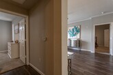This single-floor residence at San Paulo Apartments offers a thoughtfully designed layout with a warm, contemporary aesthetic throughout. Dark hardwood-style flooring runs through the main living areas, complemented by neutral gray and taupe walls that create a cohesive, inviting atmosphere.

The living room is a comfortable, light-filled space featuring crown molding, a ceiling fan, and sliding glass doors that open onto a private balcony — bringing in natural light and outdoor views of the community. Adjacent to the living room, the dining area accommodates a round table for four, accented by elegant crown molding and connected to the kitchen via a convenient pass-through counter.

The kitchen is equipped with stainless steel appliances, including a refrigerator, stove, and microwave, alongside light wood cabinetry and white countertops. A dedicated laundry area with washer and dryer hookups is accessible directly from the kitchen.

Both bedrooms feature plush carpeting, ceiling fans, and generous windows with vertical blinds for natural light and privacy. The primary bathroom offers a double-sink vanity with white cabinetry, while a second full bathroom provides a single-sink vanity and shower. An entry hallway with a thermostat and overhead ventilation connects the spaces efficiently, completing this well-organized and comfortable home.