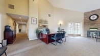 Located at 962 W Second St in Rialto, California, this single-story commercial space offers a thoughtfully designed layout across four distinct areas. The centerpiece is a spacious main reception and office area distinguished by soaring vaulted ceilings, a ceiling fan with track lighting, and warm neutral tones. A striking stacked-stone accent wall adds architectural character, while French doors invite natural light and provide outdoor access. Rich mahogany-toned desks and leather seating furnish the space professionally, creating a polished and welcoming environment for staff and visitors alike. A seating area near the entrance accommodates waiting guests comfortably. Adjacent to the main area, a dedicated computer lab features built-in dark wood cabinetry with overhead storage, granite-style countertops, plantation shutters, and multiple workstations — ideal for productivity and collaboration. Two children's activity rooms are finished with light blue walls, recessed lighting, and durable carpeting. These cheerful spaces are equipped with round tables, colorful chairs, and a wall-mounted display screen, making them well-suited for educational or group activities. A hallway connects all areas seamlessly. The restroom is fully ADA-compliant, finished with rich earth-toned stone tile on both the floors and walls, and equipped with stainless steel grab bars for accessibility. Together, these spaces form a functional and inviting facility suited for community, educational, or professional use.