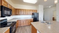 Located at 670 Fitzwater St in Salisbury, Maryland, this single-floor, 3-bedroom, 2-bathroom home presents a clean and functional layout suited for everyday living. The interior is finished with neutral tones and white trim throughout, creating a bright and cohesive atmosphere.

The kitchen is a standout feature, offering warm-toned wooden cabinetry with raised-panel detailing, granite-style countertops, and a peninsula with a built-in sink — ideal for both meal prep and casual dining. Black appliances, including a refrigerator, range, and microwave, complement the cabinetry, while pendant lighting and wood-look flooring add a polished touch.

A hallway connects the main living areas to the three bedrooms. The primary bedroom features light hardwood-style flooring and multiple windows that invite natural light and outdoor views. The two additional bedrooms are carpeted and similarly bright, with windows overlooking the surroundings. All bedrooms benefit from the home's clean, understated design.

Both bathrooms are finished consistently, featuring warm wood vanities with white countertops, mirrors, wall-mounted grab bars, and earthy ceramic tile flooring. The layout is practical and accessible. Throughout the home, the combination of wood-look and carpeted floors, crisp white walls, and ample natural light creates a welcoming and livable environment.