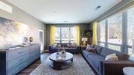Located at 250 Brodbelt Ln in Columbus, Ohio, this single-floor residence offers a well-appointed layout with contemporary finishes throughout. The spacious living room is a standout feature, showcasing dark hardwood flooring, bold gray walls, and large windows dressed with bright yellow curtains that flood the room with natural light and offer views of the surrounding neighborhood. Two generous sofas, a round coffee table, and a patterned area rug complete the inviting atmosphere.

The kitchen is thoughtfully designed with dark cabinetry, granite countertops, a white subway tile backsplash, and a full suite of stainless steel appliances including a range, microwave, refrigerator, and dishwasher — combining style with functionality.

The primary bedroom features plush carpeting, a large window with outdoor views, and ample room for a full furniture arrangement. A second bedroom provides a cozy, restful retreat with soft neutral tones and carpet flooring. The bathroom connects to a walk-in closet equipped with wire shelving and hanging storage, offering practical and organized storage space. Together, these rooms create a cohesive, modern living environment with a clean, urban aesthetic.