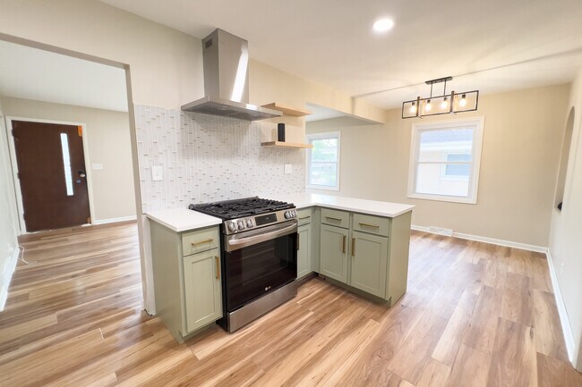 View from inside the kitchen looking at the gas range, hood, looking towards the living room and din - 811 S 88th St