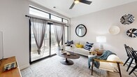 Located at 400 Waterside Dr in Norfolk, Virginia, this well-appointed one-bedroom, one-bathroom residence offers a thoughtfully designed open-concept layout that maximizes every square foot. Light wood-tone flooring flows throughout the main living areas, creating a warm and cohesive aesthetic. The modern kitchen is a standout feature, boasting white shaker cabinetry extending to the ceiling, quartz countertops, a peninsula with bar seating, stylish pendant lighting, and a full suite of stainless steel appliances including a refrigerator, range, microwave, and dishwasher. The kitchen opens seamlessly into the dining and living areas, where a ceiling fan, recessed lighting, and large sliding glass doors lead to a private balcony with outdoor views. The bedroom offers plush carpeting, a generous window with urban views, and access to ample closet storage. The clean, minimalist bathroom features wood-look tile flooring, a shower/tub combination, and black accent hardware. Additional conveniences include an in-unit laundry area and three closets throughout. The overall ambiance is bright, modern, and functional — ideal for comfortable urban living in the heart of Norfolk's waterside district.