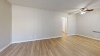 Located at 4640 Arden Way in El Monte, California, this single-story, one-bedroom, one-bathroom unit offers a practical and well-organized layout across its single floor. The living area features light wood-style flooring, neutral gray walls, and a textured ceiling, creating a clean and understated aesthetic. A wall-mounted air conditioning unit and a large window with vertical blinds allow for natural light and climate control. The kitchen runs alongside the living space in a galley-style configuration, outfitted with white cabinetry, granite-look countertops, a gas range, stainless steel refrigerator, and an over-the-range microwave. Light hardwood-style flooring extends through the kitchen, which also includes a window that brings in additional natural light. A hallway connects the main living area to the private bedroom and bathroom. The bedroom is carpeted with soft, neutral-toned carpet and features a window overlooking mature trees, providing a tranquil outdoor view. The bathroom includes a full tub-shower combination with white subway tile surround, chrome fixtures, and a window for natural ventilation. Throughout the unit, clean white trim and a consistent neutral color palette contribute to a bright, cohesive, and move-in-ready environment.