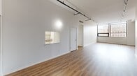 This contemporary 2-bedroom apartment in Rochester, NY offers a spacious 1110 square feet of living space on a single floor. The open-concept design creates a seamless flow between the living areas, highlighted by large windows that flood the space with natural light and provide city views.

The living room features sleek hardwood flooring and track lighting, creating a modern ambiance. The updated kitchen boasts elegant marble-like countertops, stainless steel appliances, and ample cabinetry in a neutral tone, perfect for culinary enthusiasts.

Both bedrooms are generously sized, with the primary bedroom measuring 180 square feet. Plush carpeting in the bedrooms adds comfort underfoot. The apartment includes one well-appointed bathroom with a combination tub/shower and modern fixtures.

Throughout the space, clean lines and a neutral color palette create a fresh, contemporary feel. The apartment's layout includes a convenient hallway connecting the various rooms. High ceilings and an overall sense of openness contribute to the apartment's airy atmosphere.

Located at 101–183 N Water St in Rochester, this apartment combines urban living with modern comfort, making it an ideal home for those seeking a stylish city dwelling.