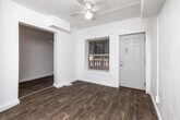 Located at 1042 18th St in Des Moines, Iowa, this single-story, three-bedroom, one-bathroom home offers a practical and functional layout. The interior is finished with a clean, neutral palette of white walls and textured ceilings throughout. Wood-look flooring runs through the hallway, kitchen, and bathroom, while plush carpeting covers the living room and all three bedrooms.

The spacious primary bedroom is the largest of the three, featuring ceiling fan lighting and two closet doors, providing ample storage. The two additional bedrooms are well-lit, each with windows that allow natural light to fill the rooms. All bedrooms include carpeted floors and closet access.

The kitchen and dining area are combined into one functional space, equipped with white cabinetry, a coil electric range, a double-basin sink, and laminate countertops. The single full bathroom features wood-look flooring, a dark-vanity cabinet with an integrated sink, a wall-mounted mirror, and a bathtub with a shower.

A central hallway connects the main living areas to the bedrooms, and the living room benefits from multiple windows offering natural light. With four closets distributed across the home, storage is well-considered throughout this straightforward and efficiently arranged single-floor residence in Des Moines.
