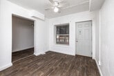 Located at 1042 18th St in Des Moines, Iowa, this single-story, three-bedroom, one-bathroom home offers a practical and functional layout. The interior is finished with a clean, neutral palette of white walls and textured ceilings throughout. Wood-look flooring runs through the hallway, kitchen, and bathroom, while plush carpeting covers the living room and all three bedrooms.

The spacious primary bedroom is the largest of the three, featuring ceiling fan lighting and two closet doors, providing ample storage. The two additional bedrooms are well-lit, each with windows that allow natural light to fill the rooms. All bedrooms include carpeted floors and closet access.

The kitchen and dining area are combined into one functional space, equipped with white cabinetry, a coil electric range, a double-basin sink, and laminate countertops. The single full bathroom features wood-look flooring, a dark-vanity cabinet with an integrated sink, a wall-mounted mirror, and a bathtub with a shower.

A central hallway connects the main living areas to the bedrooms, and the living room benefits from multiple windows offering natural light. With four closets distributed across the home, storage is well-considered throughout this straightforward and efficiently arranged single-floor residence in Des Moines.