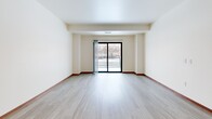 This well-appointed two-bedroom, three-bathroom residence in Shoreview, Minnesota offers a thoughtfully designed single-floor layout. The open-concept kitchen and living area serves as the heart of the home, featuring warm honey-toned cabinetry, a center island with a crisp white countertop, stainless steel appliances including a refrigerator and range, and recessed lighting throughout. Light wood-style flooring flows seamlessly through the main living space, which is filled with natural light and opens directly onto a private balcony through sliding glass doors, offering pleasant outdoor views. The spacious living area provides a clean, neutral canvas with warm wood baseboards adding a refined touch. Both bedrooms are carpeted and offer a comfortable, quiet retreat. The primary bedroom is generously sized and includes a walk-in closet with built-in shelving. Five closets total throughout the unit ensure ample storage. Each of the three bathrooms is finished with wood-toned vanities, white countertops, and tub-shower combinations. A dedicated laundry bathroom adds everyday convenience. The overall ambiance is clean, bright, and move-in ready, making this Shoreview residence a practical and comfortable home.
