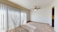 This single-floor residence at 11150 Somerset Dr in North Royalton, Ohio offers a well-organized layout with a bright, neutral aesthetic throughout. The living area is a standout space, featuring large sliding glass doors dressed with vertical blinds that allow natural light to cast across the plush carpeted floors. A ceiling fan with integrated lighting adds both function and a classic touch to the room.

The kitchen is notably updated, showcasing dark cabinetry paired with light granite-style countertops and light wood-tone flooring. It is equipped with stainless steel appliances, including a dishwasher and range, along with a stainless sink. A ceiling fan overhead adds airflow to the galley-style layout.

The bedrooms are carpeted and generously sized, with natural light provided by windows fitted with blinds. At least one bedroom includes a walk-in closet with a hanging rod for practical storage.

Two bathrooms serve the unit: one features a full tub-shower combination with white tile surround and wood-look tile flooring, while the second offers a glass-enclosed shower stall with matching dark cabinetry and wood-look flooring. Both bathrooms maintain a clean, cohesive design.